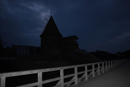The bridge across the moat on silhouette watchtower at nightの写真素材