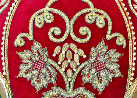 Embroidery in gold with precious stones  on red materialの写真素材