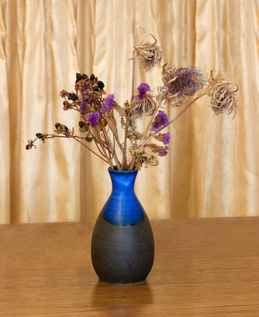 Ceramic vase with dried flowers on a beige backgroundの写真素材
