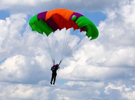 Skydiver descends by parachute. Time just before landing.の写真素材
