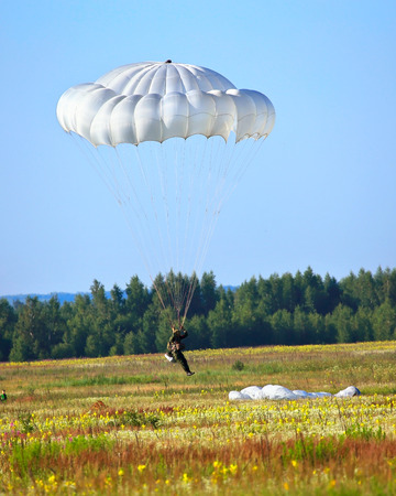 Skydiver descends by parachute. Time just before landingの写真素材
