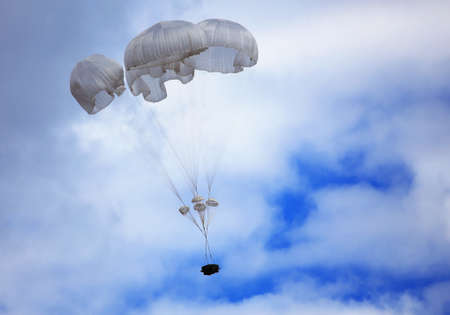 Dropping cargo using military parachute system. Time just before landingの写真素材