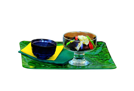 Candied fruits in transparent vase on a green trayの写真素材