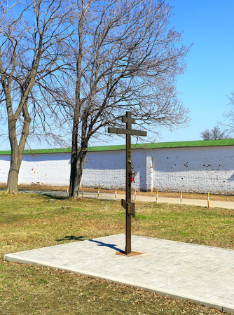 Metal Orthodox cross on a pedestal on a background of the monastery wall in Easterの写真素材