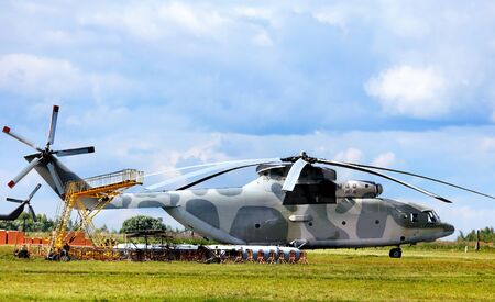 Modern russian military transport helicopter, airfield facilities and other technical equipment at the air baseのeditorial素材