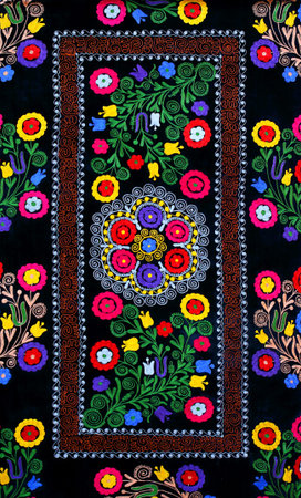 Oriental carpet with colorful patterns of plants and flowers on a black background
