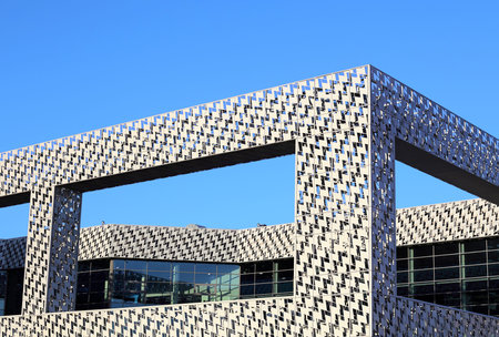 Facing the frame of a building under construction from shiny metal plates