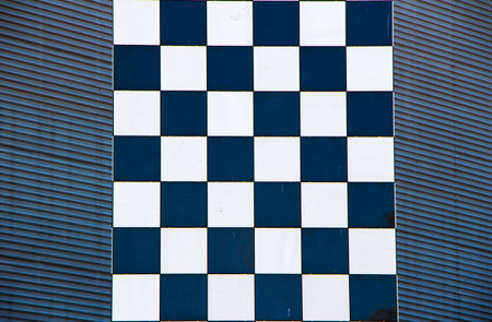 Two textures superimposed on the image, black and white mosaic column in front of corrugated facade