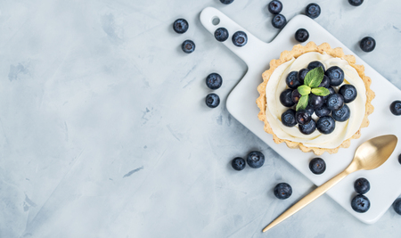 Vanilla tartlets with blueberry berries on light background. View from above and with Copy space.の写真素材