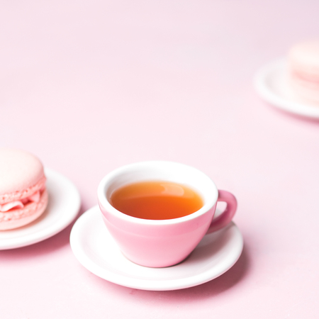 Still life with french delicious dessert macaroons and cup of coffee on pink background with copy spaceの写真素材
