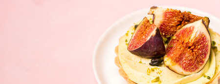 Delicious tart with fresh figs and pistachios on pink pastel backgroundsの写真素材