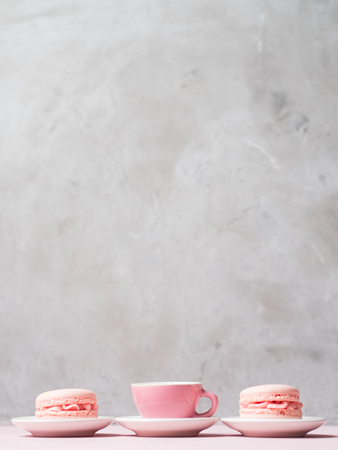 Still life with french delicious dessert macaroons and cup of coffee on pink background with copy space.の写真素材