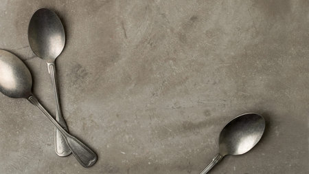 Vintage silver spoons on grey concrete background