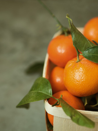 Fresh tangerines with leaves in wooden boxの写真素材