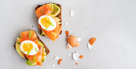 Healthy open sandwiches on multigrain wholegrain  toast with avocado, salmon, eggs, herbs, sunflower...