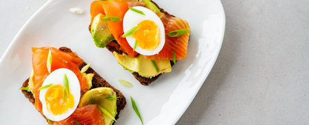 Healthy open sandwiches on multigrain wholegrain  toast with avocado, salmon, eggs, herbs, sunflower...