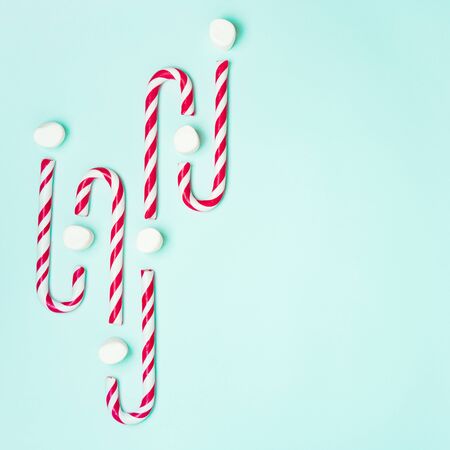Christmas layout with candy cane and marshmallows out in the form of pulse, waves or wavelike graphics on a turquoise background with space for text. Growth chart, financial concept.の写真素材