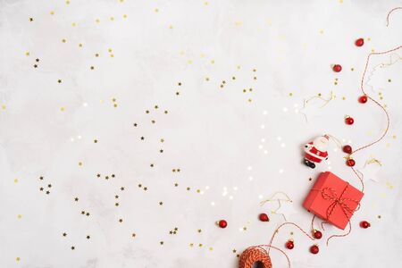 Christmas or New Year holiday winter layout with red gift boxes, rope, vintage decorations props over on white background with confetti and space for text. Wrapping presents.の写真素材