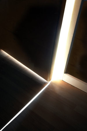 Sunlight shining through a small gap between the door an the wall