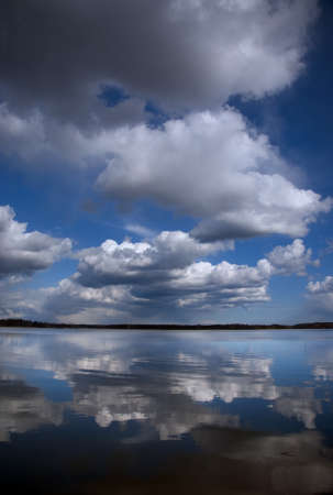 Fluffy clouds in blue sky reflected in water
の写真素材
