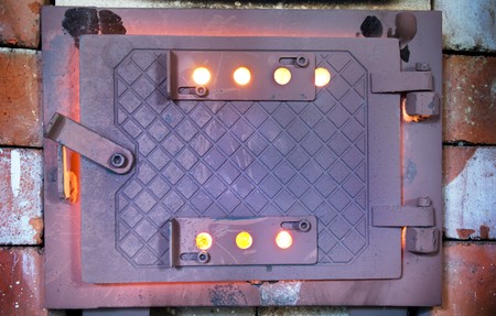 Hot rusty wood burner with the hatch slightly openの写真素材