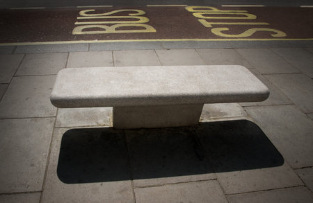 Empty stone bench at a bus stop