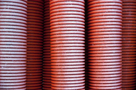 Stack of red plastic pipes with hoar frostの写真素材