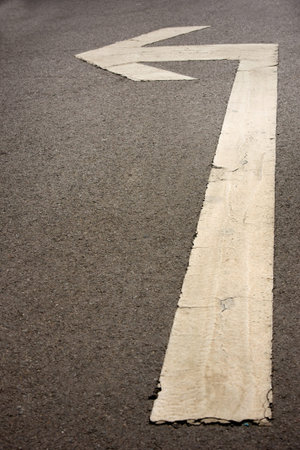 white arrow on the road pointing to the left