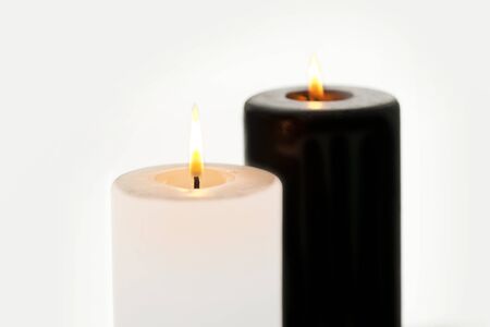 Sparse compositon with one white and one black candleの写真素材