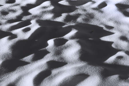 Uneven monochrome snow surface in low lightの写真素材