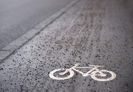 Close up of bicycle sign on sidewalk with gravel