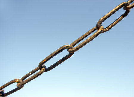 Rusty chain links on blue sky