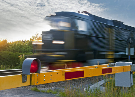 Locomotive passing at a railway crossing with red light