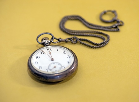 Close up of vintage pocket watch over golden backgroundの写真素材