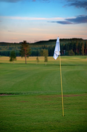 Flag on golf course in evening lightの写真素材