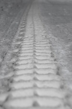 Tire track from heavy vehicle in snow on roadの写真素材