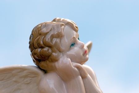 Antique porcelain angel on blue skyの写真素材
