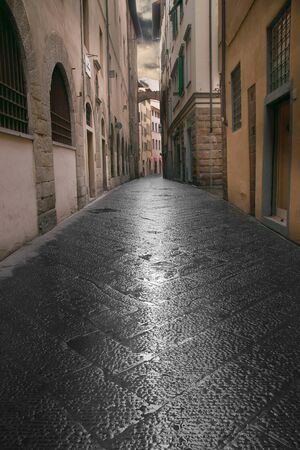Narrow street in Florence, Italy, on a cloudy rainy dayのeditorial素材