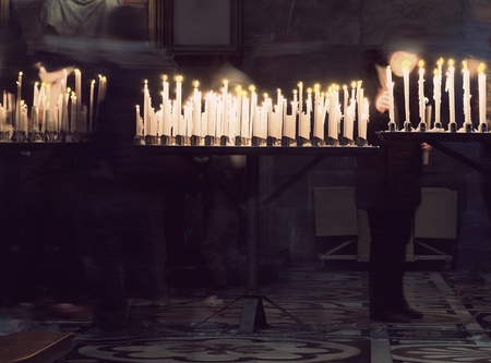 Person lighting candle in memory of relative in churchの写真素材