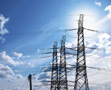 Electricity pylons on blue bright sky in sunshineの写真素材
