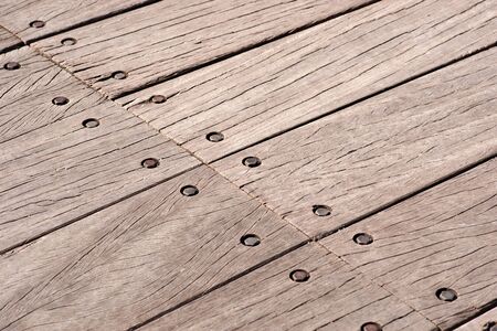 Background of bridge with weathered wooden floor fastened with boltsの写真素材