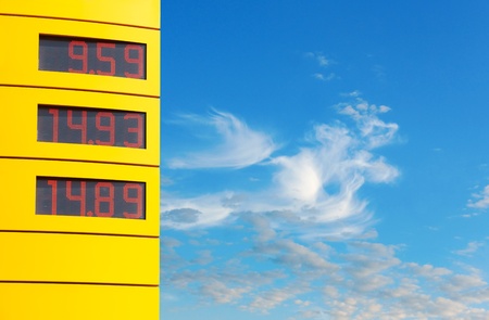 Yellow sign with gas prices on blue skyの写真素材