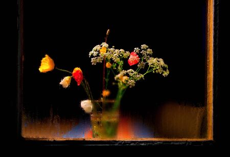 simple vase with wild flowers behind damp window at nightの写真素材
