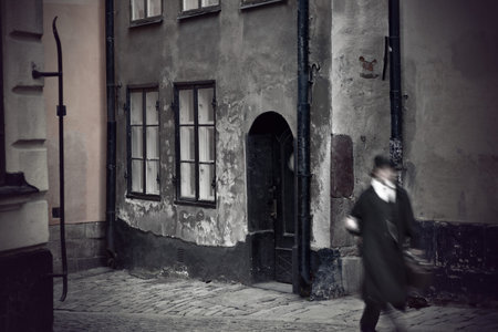medieval street with man in old fashioned clothes in blurred motionの写真素材