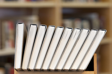 Row of books with library shelves in background