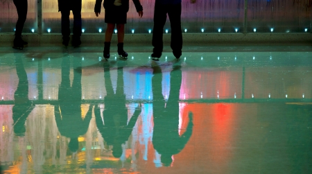 People in ice skating rink with mulii colored lightsの写真素材