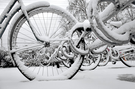 Close up of wheel of bike in bicycle rack in winterの写真素材