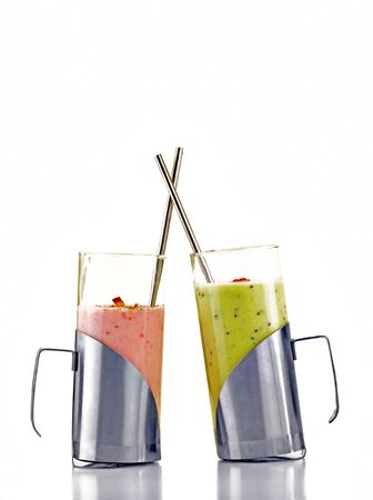 Colorful fruit drinks in glasses with straws isolated on whiteの写真素材