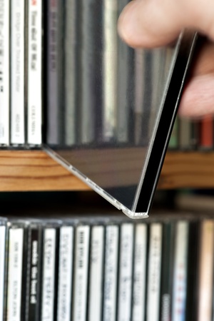 close up of man taking out CD from collection on shelfの写真素材