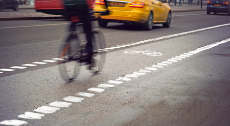 Cyclist in blurred motion in busy street on gloomy rainy day